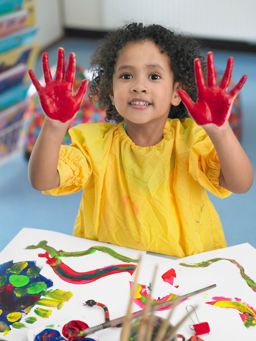 Girl finger painting in art class elevated view